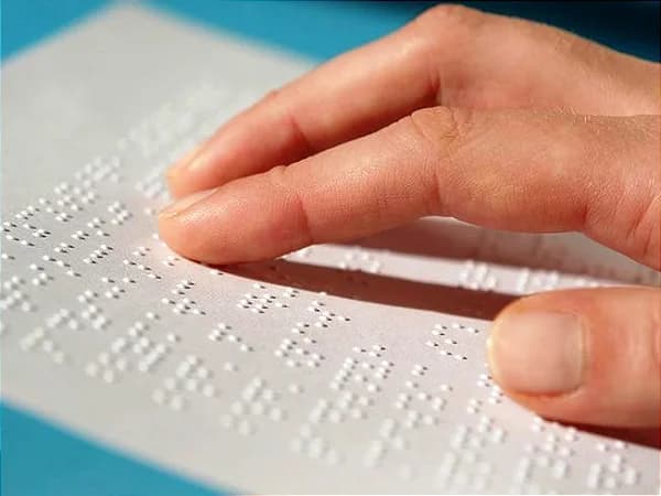 Pessoa com deficiência visual lendo Braille
